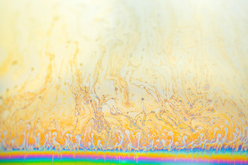 soap bubble surface with rainbow below, iridescent surface