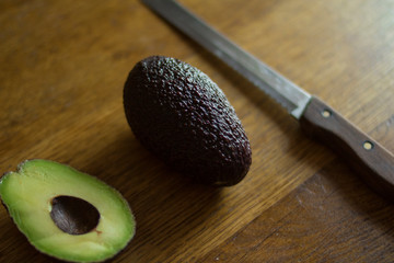 Fresh green tasty avocado lies in clay natural dishes on a wooden oak table
