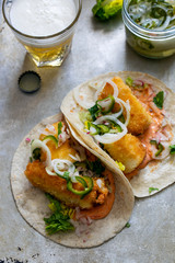 Fish tacos with cod, harrisa sauce, pickled onions and chili