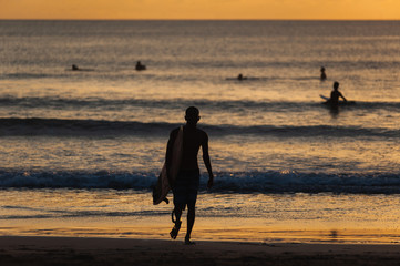 Fototapeta na wymiar Black silhouette of a surfer with a board