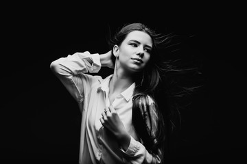 Beauty. Femininity. Beautiful female face with perfect genuine skin. Beauty salon. Make-up artist. Portrait of a beautiful woman in the studio. The girl inflates her hair. Girl in a white shirt. Face.