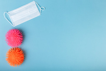 Coronaviruses or the other infectious microbes of orange and pink color sit near the medical mask...