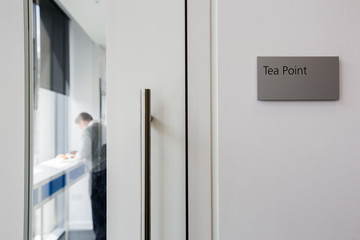 Tea point and pantry sign in office on wall by door at office