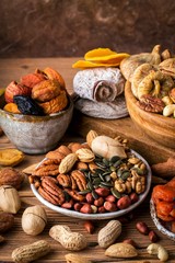 Composition from mix of nuts and dried fruits. Brown background, vertical format