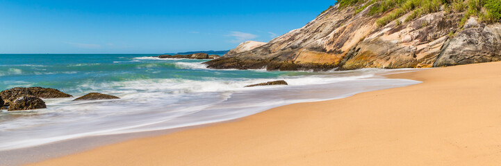 Tropical beach with panoramic views and waves, rocks and sand background. Travel destinations in Brazil and banner web.