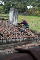 old roof and view of old tiles, roof before renovation, before repair, man on the roof