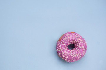 Donuts glazed with sprinkles on a blue background, copy space