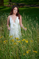 Naklejka na ściany i meble Stunning young Caucasian woman poses in white dressing field - summer fashion