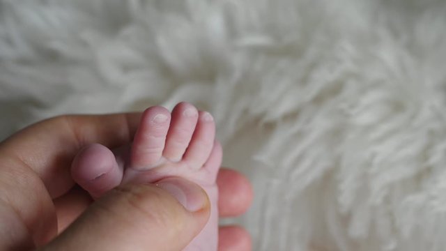 hand holding little cute newborn child foot fingers tootsy babinski sign