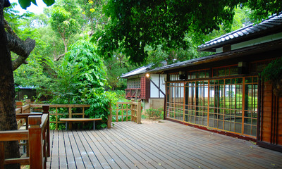 Traditional asian architecture with wooden terrace in green surrounding