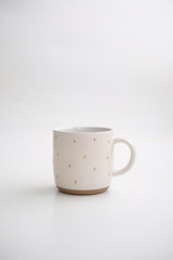 Ceramic mug for hot coffee or tea drinks decorated with asterisks. Cup on a white isolated background.