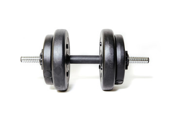 Fototapeta na wymiar Dumbbells on a light background. The concept of sport and training, the weights lie on the ground. Black dumbbells ready for exercise, taking care of your figure and physical health.