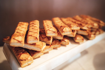 Fresh baked traditional Italian dessert sfogliatine on white tray. Glazed puff pastry biscuits. Celebration, party, birthday or wedding concept.