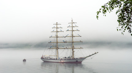 Fototapeta premium Big and tall sail ship in Geiranger fjord in Norway during misty day.