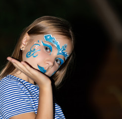 Girl with blue eyes and face painting, aqua mask