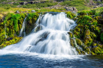 Obraz premium Green and colorful waterfall scenery with textured moss, clear and fresh water, cacades and landscape details.