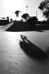 Grayscale shot of a male doing tricks with a skateboard © Juan Naranjo/Wirestock