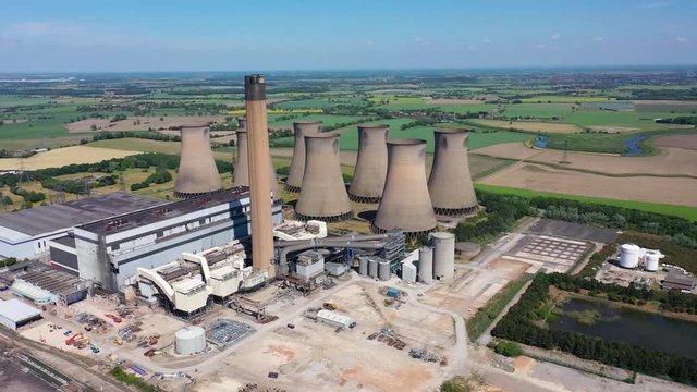 Aerial footage of the Eggborough Power station showing the eight cooling towers and chimneys along side farmers fields on a bright sunny summers day located in Goole, West Riding of West Yorkshire