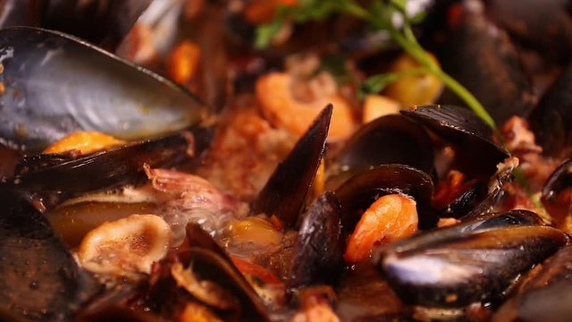 Cooked on the stove traditional Italian Mediterranean fish soup, chowder,with shrimp, mussels tomato, squid, clams.Seafood.Close up