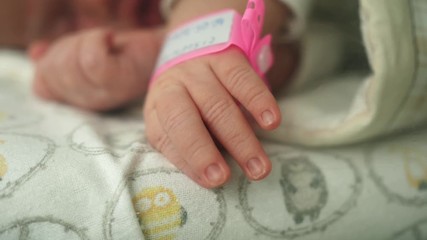 infant newborn hand arm wrist pink girl band hospital  identification wristband