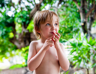 Young caucasian boy with malicious or inquisitive expression on face enjoys the outdoors. Location Hawaii.