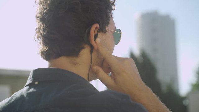 Secret agent talking to two way radio earpiece during a lookout on city roof