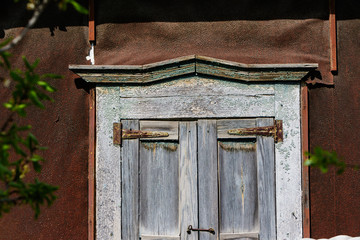 Vintage window with shutters on the old wall.