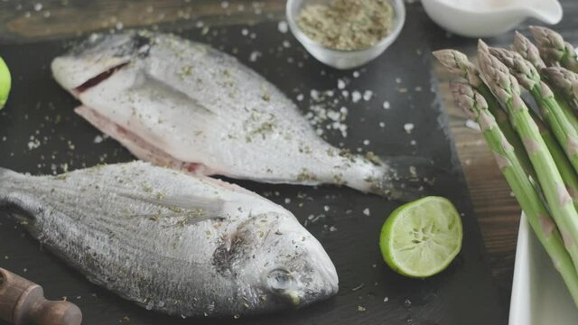 the cook prepares for baking dorado fish with asparagus. removed from the fish internals and toads, rubbed it with salt and spices and lime juice.