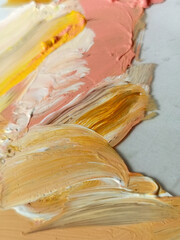 paint smeared on a palette in delicate ochre pink tones