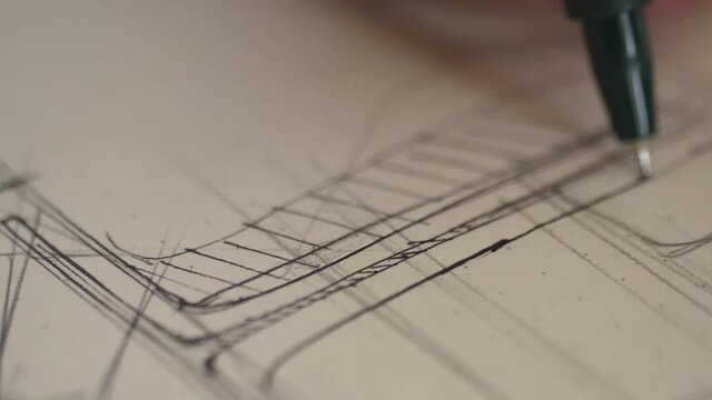 designer draws sketch with fine point pen 