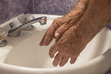 Bathroom sink two hands getting ready to wash