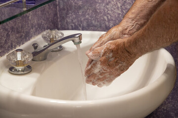 Soaping hands with running water bathroom sink horizontal