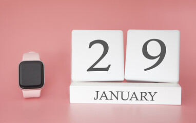 Modern Watch with cube calendar and date 29 january on pink background. Concept winter time vacation.