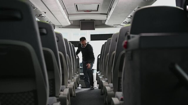 Intercity Bus Coach Driver Preparing His Bus For the Next Trip Looking For Things Left by Clients and Garbage.