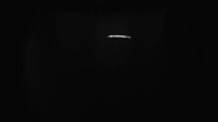 Coin spinning on black background - Powered by Adobe