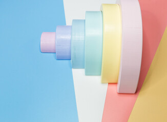 Wooden toy rainbow, pastel color arc on pink blue white orange background. Natural toys for creativity development. Flat lay, top view. Educational games for kindergarten, preschool kids