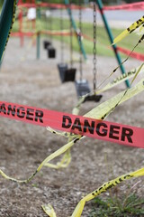 Danger tape is wrapped around playground equipment, indicating the park is closed due to Covid-19 concerns.