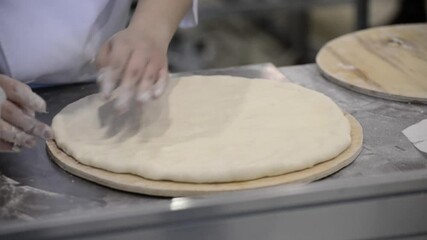Cook's hands knead the dough.