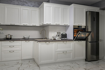 Electric appliances in minimalistic white kitchen interior