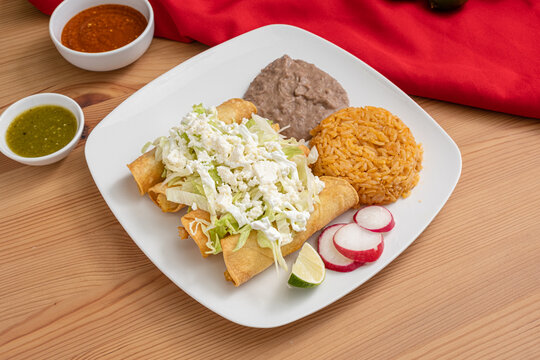 Traditional Mexican flautas or taquitos served with rice and beans. Delicious and cheap Hispanic inspired cuisine.
