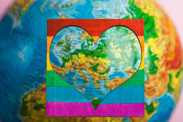 LGBT and pride day.Rainbow colored heart with symbols of lesbians, gays, transgender people and bisexuals on a globe background.