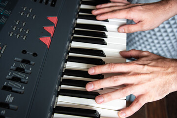 Fototapeta na wymiar Male playing the piano keyboard close up