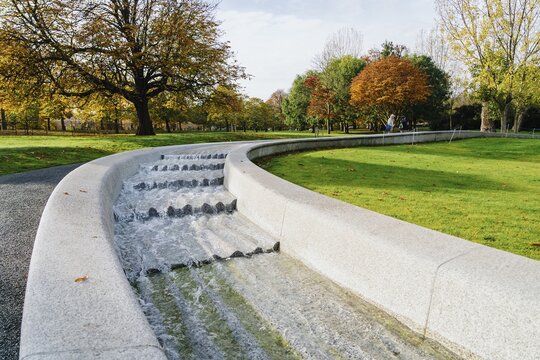 Princess Diana Memorial Fountain surrounded by greenery under the sunlight in London, England