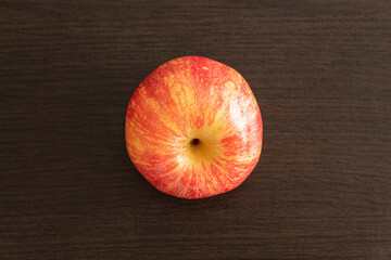 Top View to a fresh red apple over a dark brown wooden table