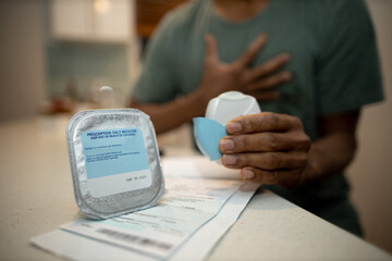 Asthma prescription drug does paper placing on the kitchen bench with defocused breathless chest pain Asthmatic person holding bottle as a lit is opening ready to use inhalled 