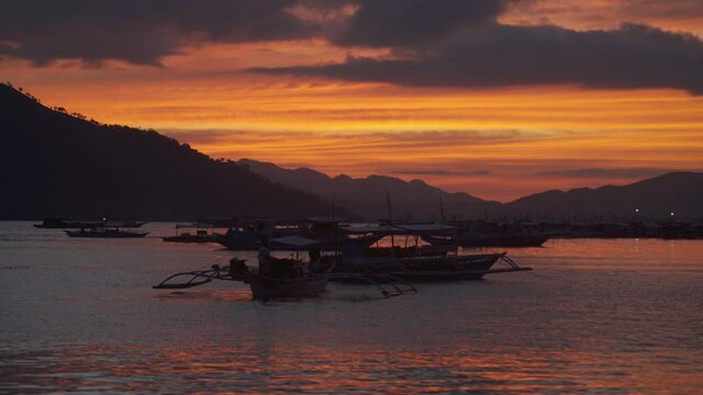 Fishermen working during sunset at Coron harbour, Busuanga, Philippines.