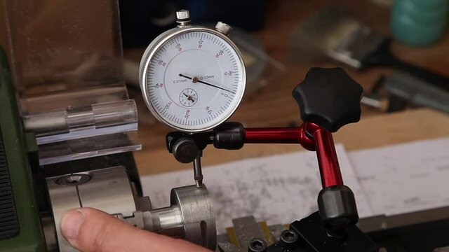 man using micrometer clock precision dial test indicator gauge scale