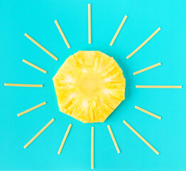 Creative summer minimal concept. Sun made of yellow pineapple round slice and spaghetti as sun rays on bright blue background. Food and fruit layout, flatlay, mockup.