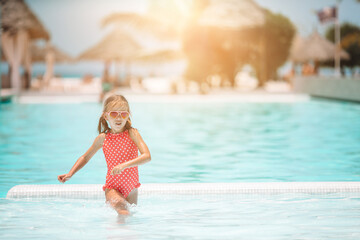 Little adorable girl in outdoor swimming pool