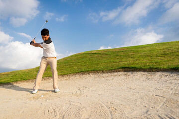 Golfers get ready to exploding sand in the bunker. Outdoor sports and recreation Concept.